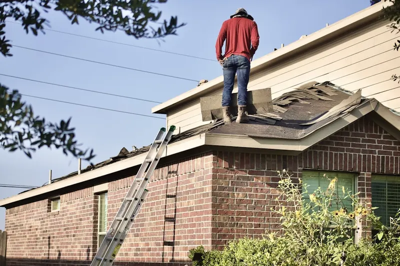 Professional roofer working on a residential roof in Elm Park Village